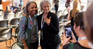 An image of two people posing for a photo at a government event.